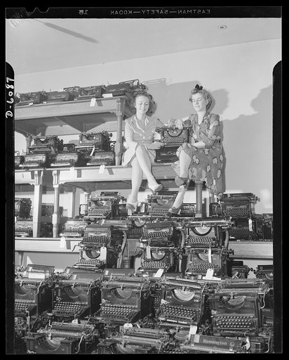 Two Metropolitan Life girl employees amidst typewriters; part of a lot being sold to the government by Metropolitan Life