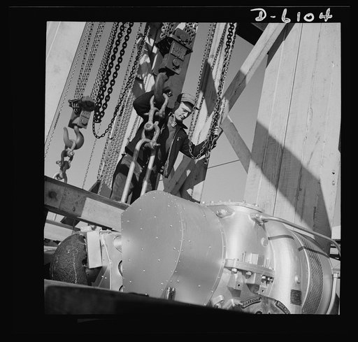 Production. Submarine chasers. Bad news for U-boats. A powerful marine diesel engine is lowered to its bed in the hull of a 173-foot steel subchaser at an Eastern boatyard. Marine Construction Company, Stamford, Connecticut