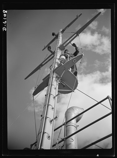 Production. Submarine chasers. They'll sight the U-boats from this crow's nest of a subchaser under construction at an Eastern boatyard. The first painting being given the mast and spars will be repeated many times during the vessel's term of service. A sailor never gets very far away from a paint p
