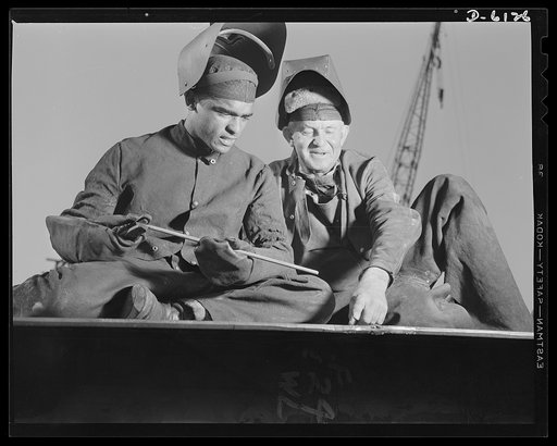 Construction of the liberty ship "Booker T. Washington." Ernest Enloe Cotton, former Tuskegee student now employed by the California Shipbuilding Corporation, is shown with a lead man examining the weld-head put on a section of the double bottom of a liberty ship. The "Booker T. Washington," first s