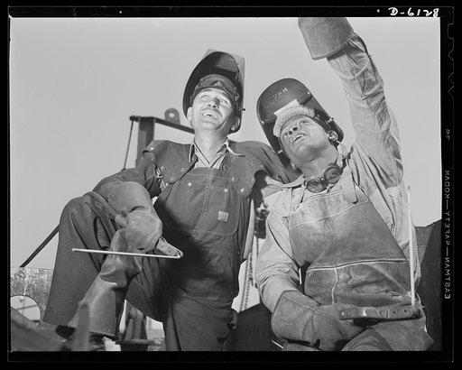 Construction of the liberty ship "Booker T. Washington." T.W. Cole and Howard Glover, white and Negro welders at the California Shipbuilding Corporation, are shown watching a crane operator hoist steel plates into place on the "Booker T. Washington," first liberty ship to be named for a Negro