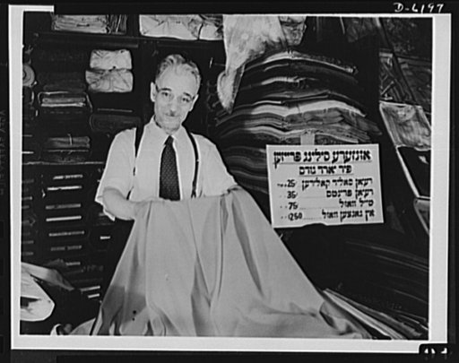 Posting ceiling prices in foreign languages. Mr. H. Brodskey is proud of the quality of the yard goods he carries at his marketplace stand in New York's East Side. He is proud too that he is aiding his government in the fight against inflation by displaying a price ceiling sign printed in Yiddish so