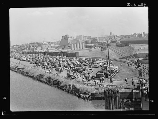 Production. Submarines. Before gasoline rationing, in a Midwest shipyard's parking lot. Today, this same view would probably show fewer cars, as workers all over the country have formed car pool clubs to save tires and gasoline