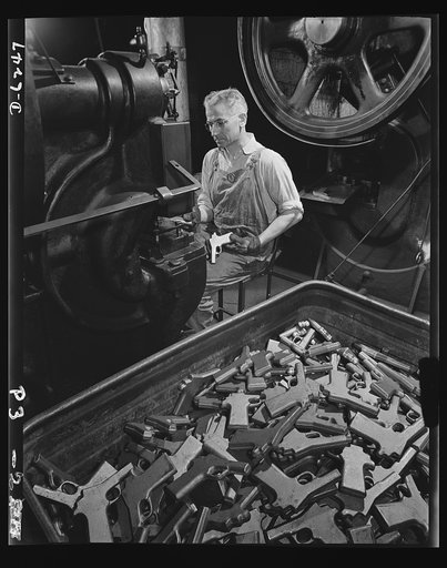 Production. 45-caliber pistols. John Ignacek pierces trigger hole guards on .45-caliber automatic pistols in the plant of a large manufacturer of firearms. The plant produces pistols, machine guns and other weapons that will soon be spreading trouble for the Axis. Many men and women are employed in 