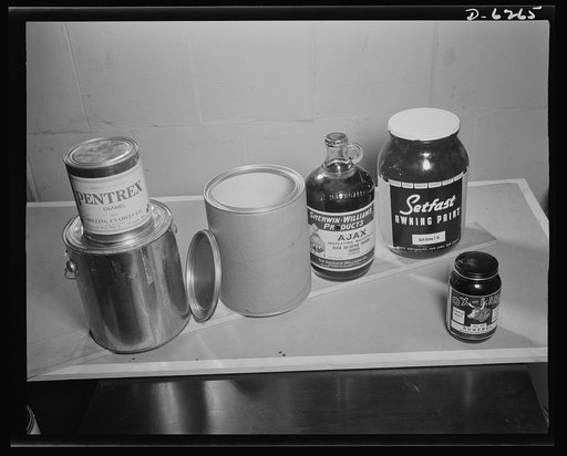 Substitute materials containers. New and old paint containers. Left to right: one-quarter metal can on one-gallon metal can, one-gallon fiber container with metal ends, one-half gallon bottle, one-gallon bottle. In the right foreground is a one-pint glass container