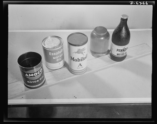 Substitute materials containers. New and old paint containers. Left to right: metal oil can, fiber containers with metal ends, all fiber containers, model of proposed glass container, glass container with metal cap