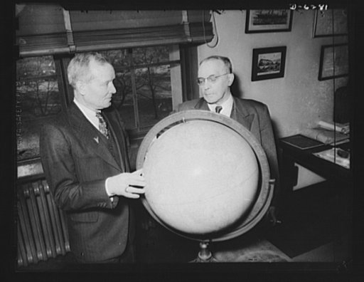Sir Arthur Salter, head of the British Shipping Mission, and Admiral Emory S. Land, War Shipping Administrator, representatives of Great Britain and the United States respectively, on the Combined Shipping Adjustment Board, study the world routes of United Nations ships at the offices of the Board i