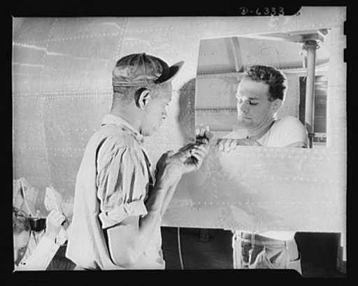 Americans all. In the armed forces and on the production line, Americans of every race and creed fight shoulder to shoulder to defeat the forces which threaten to destroy our liberties. Here, George Knockel (bucking rivet) and Lewis Ward work on the fuselage of a P-47 pursuit ship in an Eastern airc