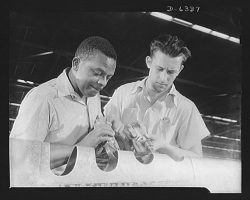 Americans all. In the armed forces and on the production line, Americans of every race and creed fight shoulder to shoulder to defeat the forces which threaten to destroy their liberties. Marcell Webb (Negro) and Walter Hyne are finishing the leading edge of the wing of a D-47 pursuit ship. The four