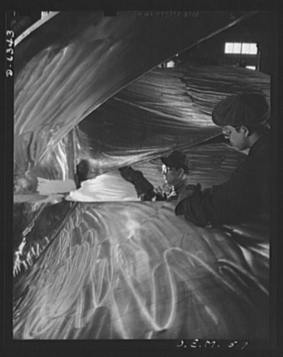 Production. Ship propellers, etc. Surrounded by the blades of huge manganese bronze ship propellers, workman of a large war production plant chip off surface irregularities with pneumatic hammers. Baldwin Locomotive Works