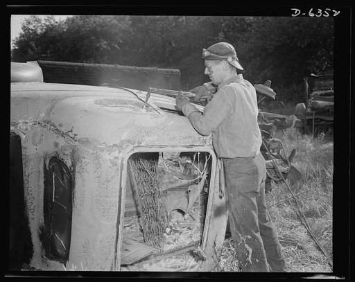 Automobile salvage. Automobile bodies are usually cut into four pieces so they can be readily loaded into a press for baling. The acetylene torch separates the lightweight body from the heavyweight steel frame of the car. Note: the auto has already been burned to remove all wooden parts, upholstery,