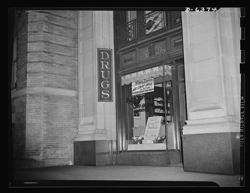 War stamp drive poster displayed in drugstore window under sponsorship of American drug trade