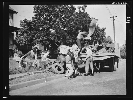Manpower, junior size. What's a home without its sidewalk scrap pile? Junior commandos of Roanoke, Virginia see to it that each home has given enough scrap to make the scrap collectors monthly visit worthwhile. When the truck appears, every youngster in the neighborhood pitches in to help load it