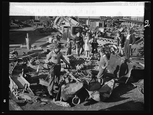 Manpower, junior size. Proud young fighters in Uncle Sam's junior army visit a scrap yard in Roanoke, Virginia to see for themselves what happens to the scrap they collect for our war industries. One of the workers explains to the children how the acetylene torch he holds cuts heavy metal into the s