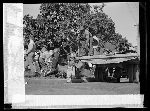 Manpower, junior size. What's a home without its sidewalk scrap pile? Junior commandos of Roanoke, Virginia see to it that each home has given enough scrap to make the scrap collectors monthly visit worthwhile. When the truck appears, every youngster in the neighborhood pitches in to help load it