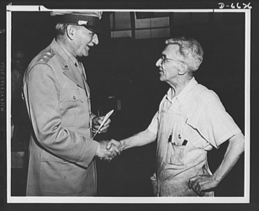 General Knudsen congratulates a production soldier. Lieutenant General William S. Knudsen is shown congratulating Thomas B. Williams, sixty-eight, of Philadelphia, a machinist on war work in the RCA Manufacturing Company, Camden, New Jersey, on the part he is taking in the present war. Mr. Williams 