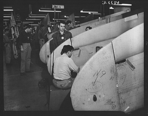 Production. Lockheed P-38 pursuit planes. Finishing wings for Lockheed P-38 pursuit planes in a large Western aircraft plant. The wings, which had been accurately assembled in jigs, are added to the plane bodies as they travel down the final assembly line where engines, landing gear, controls and ot