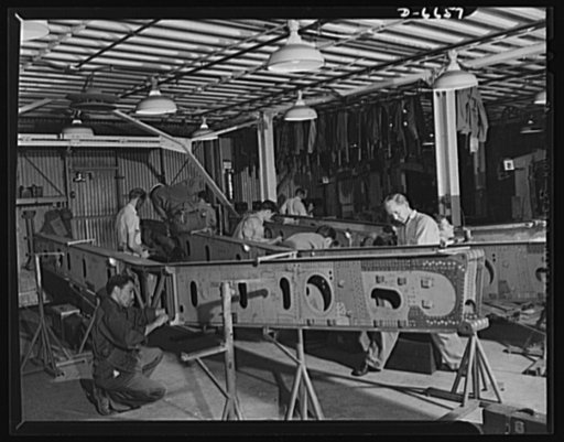 Production. Lockheed P-38 pursuit planes. Finishing a main beam for the center section of a Lockheed P-38 pursuit plane. When the center section of the ship is completed it will go to a "mating" operation in which other plane sections are attached to it. The plane body will then travel down the main