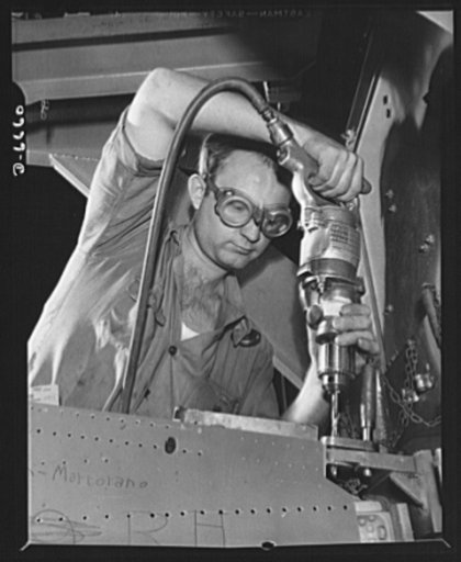 Production. Lockheed P-38 pursuit planes. A drill operator in a Western aircraft plant, using a drill jig on the center section of a Lockheed P-38 pursuit plane. On the final assembly line, the completed center section will be joined to other plane sections, and noses, engines, wings, landing gear a