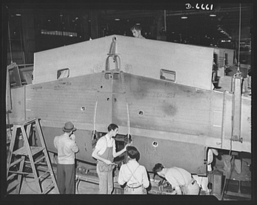 Production. Lockheed P-38 pursuit planes. Fittings are attached to a center section of a Lockheed P-38 pursuit ship in a large Western aircraft plant. On the final assembly line, the completed center section will be joined to other plane sections, and noses, engines, wings, landing gear and other eq