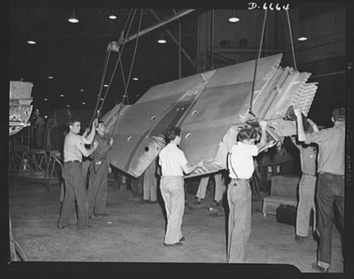 Production. Lockheed P-38 pursuit planes. The center section for a Lockheed P-38 pursuit ship ready to go into a "mating" jig at a large Western aircraft plant. In the "mating" operation, nose sections and other plane members are joined to the center section. The partly-finished plane body is then r