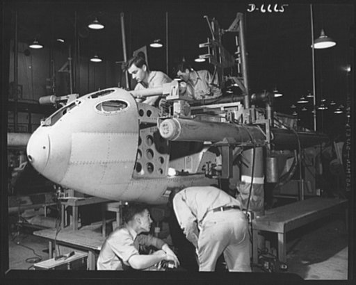 Production. Lockheed P-38 pursuit planes. The nose section of a new Lockheed P-38 pursuit ship in a jig at a large Western aircraft plant. This nose section will later be joined or "mated" to a center section and the partly-finished body will begin its trip down the final assembly line where engines