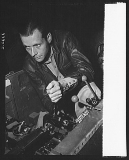 Production. Lockheed P-38 pursuit planes. An armorer in a large Western aircraft plant tests machine gun controls in the partly-finished nose section of a new Lockheed P-38 pursuit plane. This section is now ready for the operation of "mating" it to the center section. The ship will travel down the 