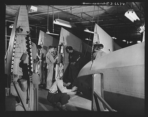 Production. Lockheed P-38 pursuit planes. Finishing wings for Lockheed P-38 pursuit planes in a large Western aircraft plant. The wings, which were accurately assembled in jigs, are added to the plane bodies as they travel down the final assembly line where engines, landing gear, controls and other 