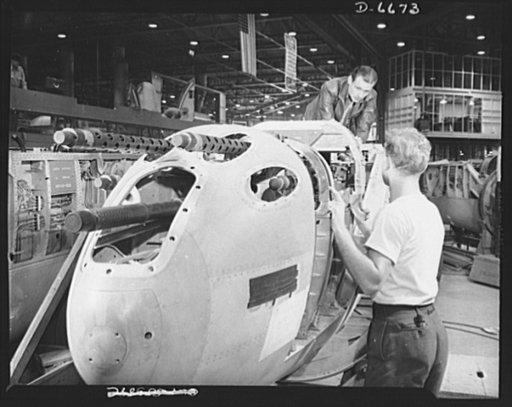 Production. Lockheed P-38 pursuit planes. An armorer and his assistant check machine gun controls in a nose section of a new Lockheed P-38 pursuit ship. The guns are cocked and simulated firing is conducted to assure perfect operation of the control and selector systems. This nose section will later