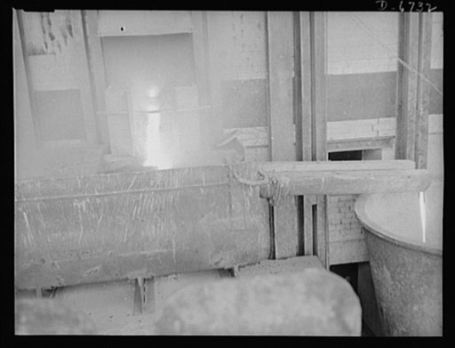 Production. Tin smelting. Removing slag after tapping a furnace in a Southern tin smelter. The tin extracted from the ore has already been drawn off into floats for further refining. The slag is then run off to the right into ladles which will carry it to recooking operations. The slag is reintroduc