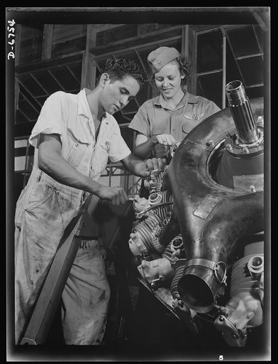 Naval air base. Corpus Christi, Texas. Now an expert mechanic, Mary Josephine Farley shows a National Youth Administration (NYA) trainee the tricks of a Wright Whirlwind motor. He will act as her helper for about eight weeks, then he'll be qualified to work on motors for the naval air base at Corpus