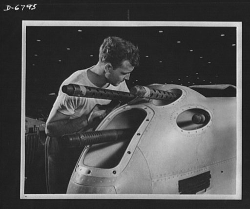 Production. Lockheed P-38 pursuit plane. An armorer's assistant in a large Western aircraft plant works on the installation of one of the machine guns in the nose section of a new Lockheed P-38 pursuit plane. This nose section will later be "mated" to a center section and the plane body will travel 