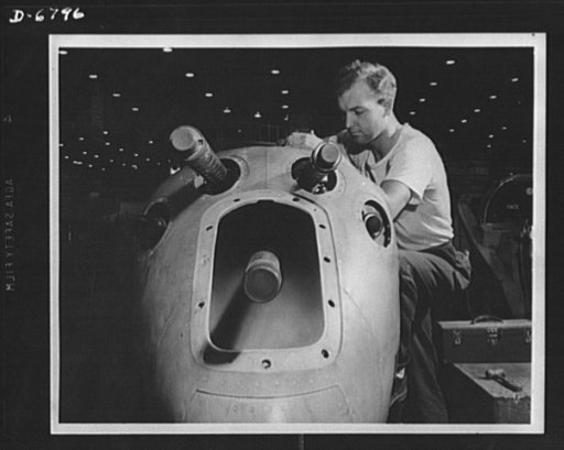 Production. Lockheed P-38 pursuit plane. An armorer's assistant in a large Western aircraft plant works on the installation of one of the machine guns in the nose section of a new Lockheed P-38 pursuit plane. This nose section will later be "mated" to a center section and the plane body will travel 