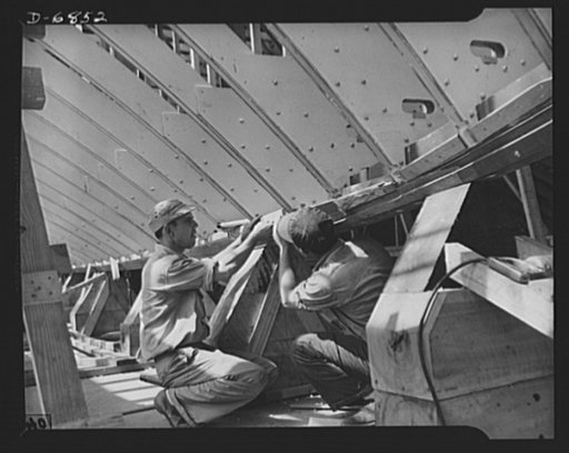 Production. Motor torpedo boats (wooden). Prefabricated frame sections of a new seventy-eight-foot wooden torpedo boat are joined to the keel at a Southern shipyard. Many speedy motor-driven fighters of this class are built here indoors, of ready-made sections. The completed hulls are then moved to 