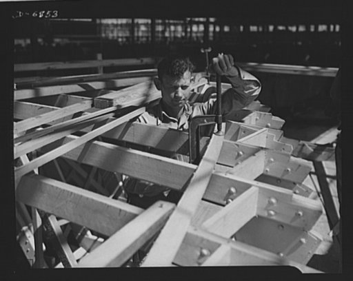 Production. Motor torpedo boats (wooden). Setting deck beam sections for a new seventy-eight-foot motor torpedo boat at a large Southern shipyard. These fast boats are built of prefabricated parts and sections under roof. When the hulls are ready for launching and fitting they are moved from the pla