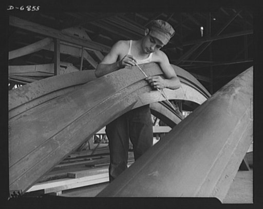 Production. Motor torpedo boats (wooden). Checking a prefabricated section for a wooden torpedo boat at a Southern shipyard. Many fast seventy-eight-foot motor driven boats of this class are built here indoors, of ready-made sections. The completed hulls are then moved to nearby water for launching 