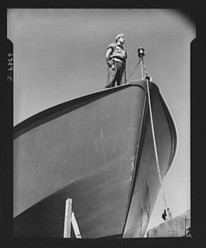 Production. Motor torpedo boats (wooden). A Coast Guard sentry stands watch over a new torpedo boat under construction at a Southern shipyard. In addition to wooden torpedo boats, the yard also turns out many steel boats for the Navy. Higgins Industries