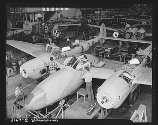 Production. Lockheed P-38 pursuit planes. A new Lockheed P-38 pursuit plane takes form on the production line. The wings and the Allison engines are already in place, and the ship now stands on its own wheels. It still requires many detail jobs before completion, but they are done rapidly under a we