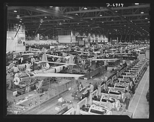 Production. Lockheed P-38 pursuit planes. Overall assembly line for Lockheed P-38 pursuit planes. A row of Allison engines reaches back from the right foreground. Under the American flag in the left background is the "Lightning" assembly line, a duplicate of the P-38 line