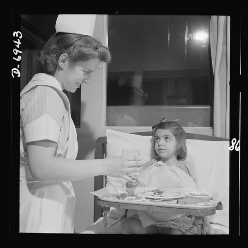 Nurse training. A convalescing youngster gets lunch with a smile from a student nurse