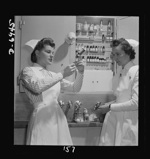 Nurse training. A graduate nurse (right) watches student Susan Petty prepare a hypodermic for a patient. Strict adherence to doctors' orders is something every probationer must learn