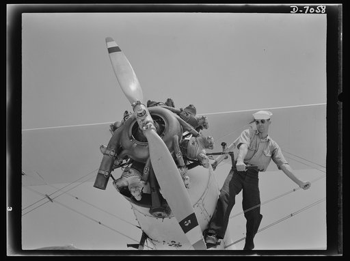 Naval air base, Corpus Christi, Texas. A couple of cranks--and let her go! Sailors at the naval air base in Corpus, Christi, Texas, start the N3N training ships in this way for the Navy pilots at the base who fly the planes
