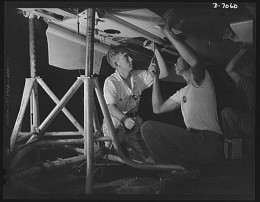 Naval air base, Corpus Christi, Texas. Highly technical training is given to an National Youth Administration (NYA) trainee (left) which will make him valuable to the Army or Navy mechanized units should he be called to service. He is helper to a Civil Service sheet metal worker (right) in the assem