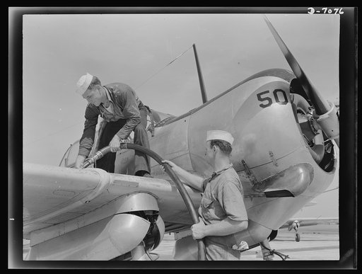 Naval air base, Corpus Christi, Texas. Feeding an SNC advanced training plane its essential supply of gasoline is done by sailor mechanics at the naval air base in Corpus Christi, Texas. Standing on the wing is Floyd Helphrey who came from Iowa to join the Navy early in the year. At right is W. Gard