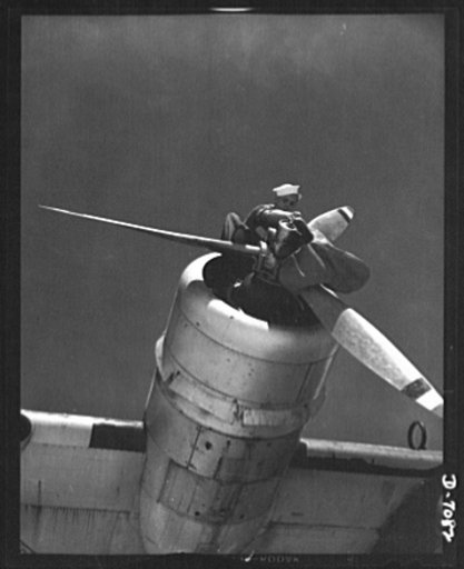 Naval air base, Corpus Christi, Texas. Perched high in the nose of a plane, this sailor mechanic is inspecting a Navy PBY at the naval air base in Corpus Christi, Texas. The ship has been reconditioned by civil service employee in the assembly and repair Department at the base. Every ship, after ful