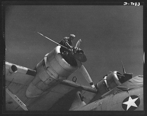 Naval air base, Corpus Christi, Texas. Perched high in the nose of a plane, this sailor mechanic is inspecting a Navy PBY at the naval air base in Corpus Christi, Texas. The ship has been reconditioned by civil service employee in the assembly and repair Department at the base. Every ship, after ful