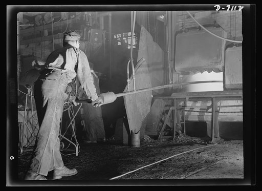 Production. 105 millimeter shells. In a Midwest foundry where plumbing fixtures were formerly processed, hot billets, soon to become shells, are rolled from a butane gas furnace by a water cooled hook. The red-hot billets will next be transferred to hydraulic presses for further processing (Manitowa