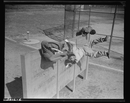 High school Victory Corps. Surmounting an eight-foot obstacle at top speed is one of the features of the rigorous "commando" training which the boys of Flushing High School, Queens, New York, receive. When the boys finish this program they will be in top they will be in top physical condition if nee