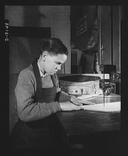 High school Victory Corps. Donald Alman, 15-year-old student at McKinley Technical High School, Washington, D.C., operates a handsaw to cut out the wing of a model plane. McKinley is one of the 6,000 schools throughout the country which provides facilities for pupils to build model planes. The plane