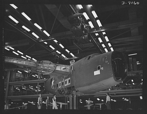Production. B-24 bombers and C-87 transports. Mated sections of a consolidated transport plane are lifted by a monorail crane from a fuselage mating fixture of a Western aircraft plant.  It will next be deposited in a carriage which will carry it along the assembly line. This new transport, an adapt